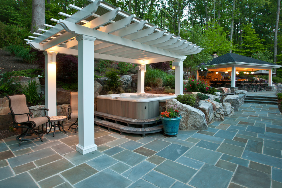 Imagen de patio clásico renovado de tamaño medio en patio trasero y anexo de casas con adoquines de piedra natural