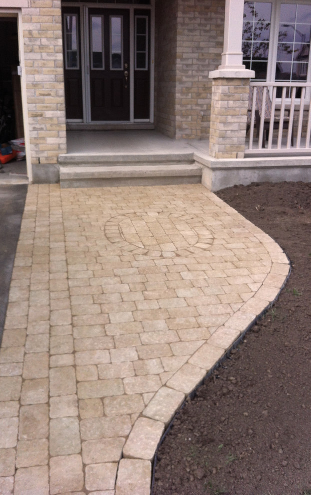 Inspiration for a medium sized modern front patio in Ottawa with brick paving and no cover.