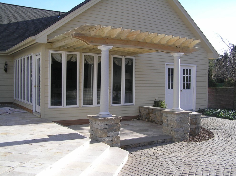 Inspiration for a large timeless backyard stone patio remodel in New York with a pergola