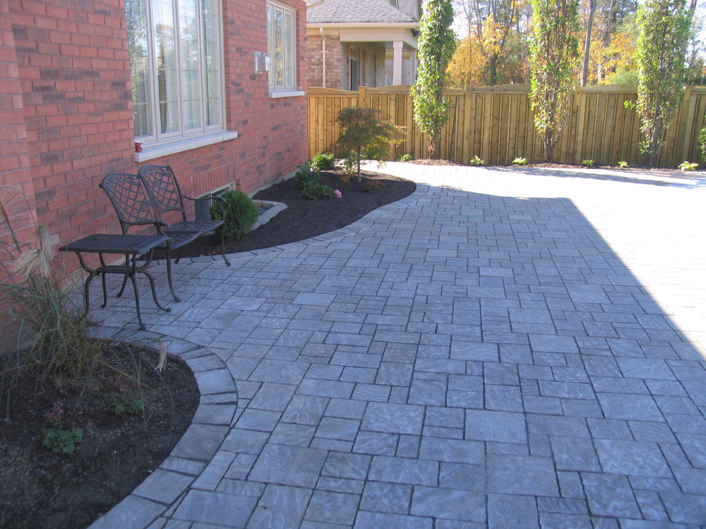 Elegant front yard stone patio photo in Toronto with no cover