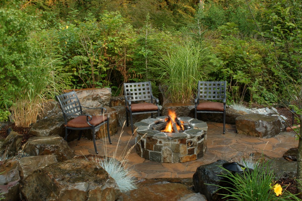 Photo of a classic patio in Seattle with a fire feature, natural stone paving and no cover.