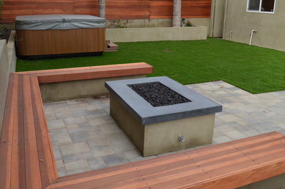 Foto di un grande patio o portico minimalista dietro casa con un focolare, pavimentazioni in pietra naturale e nessuna copertura
