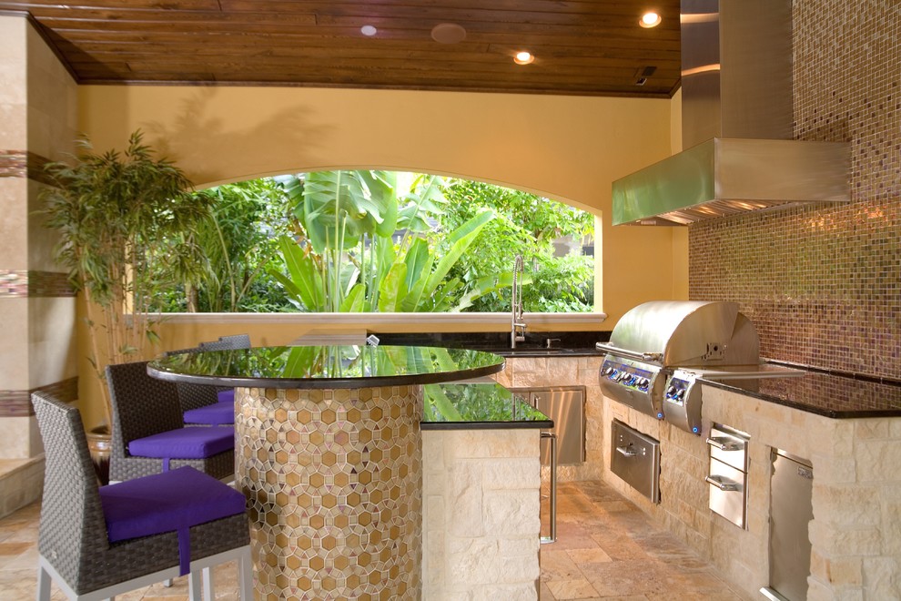 На фото: двор среднего размера на заднем дворе в средиземноморском стиле с летней кухней, покрытием из плитки и навесом с