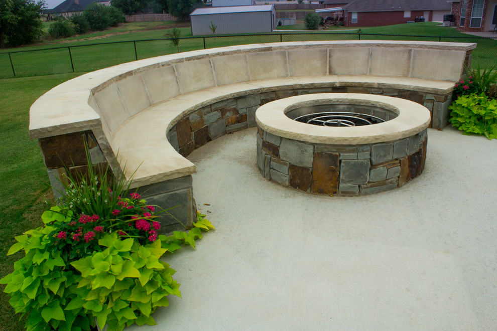 Mid-sized mountain style backyard stamped concrete patio photo in Oklahoma City with a fire pit and a pergola