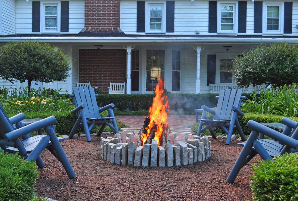 Medium sized farmhouse courtyard patio in Chicago with a fire feature, gravel and a pergola.