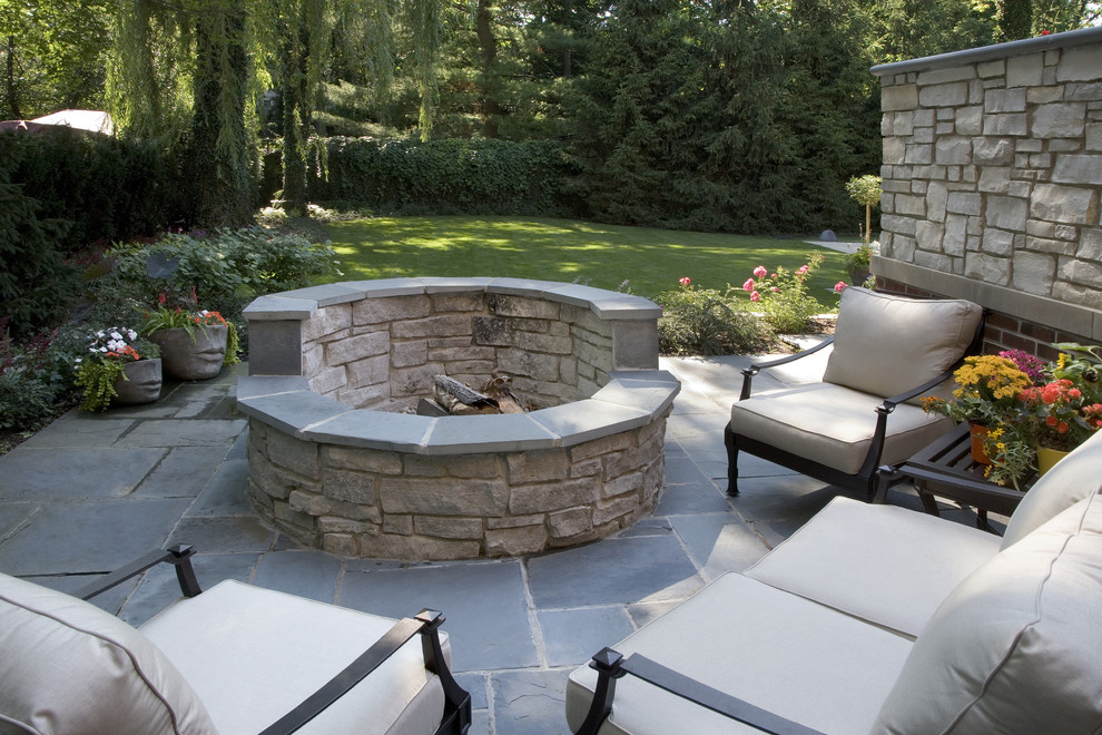 Trendy backyard stone patio photo in Chicago with a fire pit and no cover