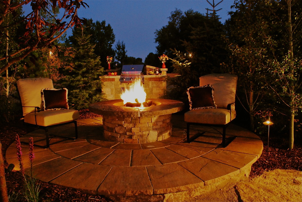 Mountain style backyard stone patio photo in Denver with a fire pit
