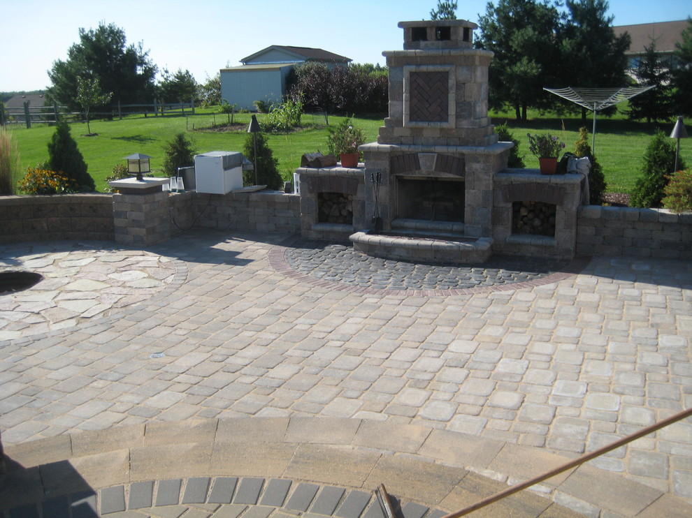 Inspiration for a large timeless backyard concrete paver patio remodel in Other with a fire pit