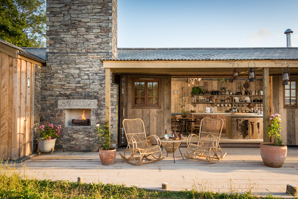 Inspiration pour une terrasse arrière chalet avec une cuisine d'été et une extension de toiture.