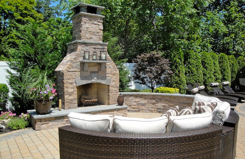 Inspiration for a large timeless backyard brick patio remodel in New York with a fire pit and no cover