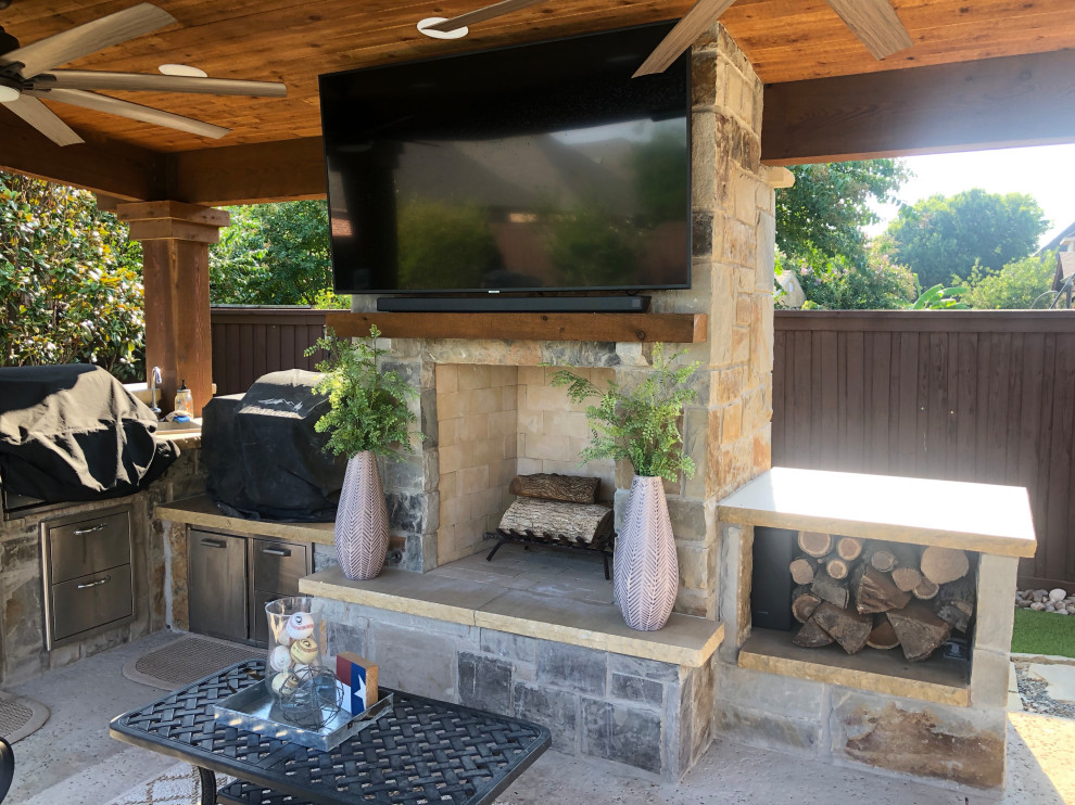 Example of a mid-sized mountain style backyard concrete patio design in Dallas with a fireplace and a gazebo