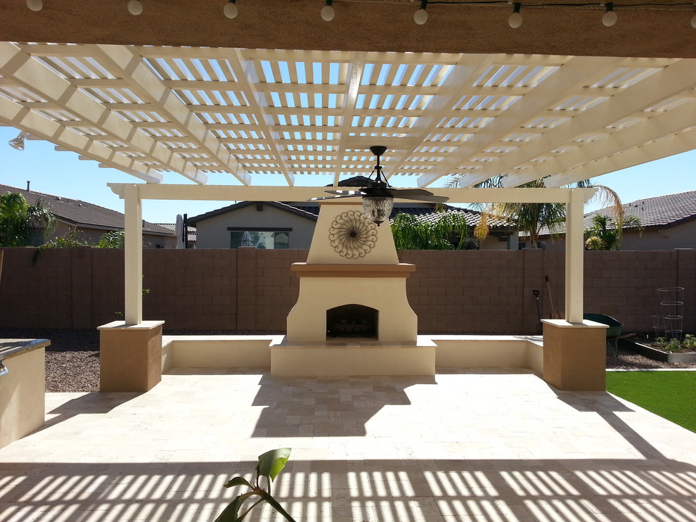Large southwest backyard stone patio photo in Phoenix with a fire pit and a pergola