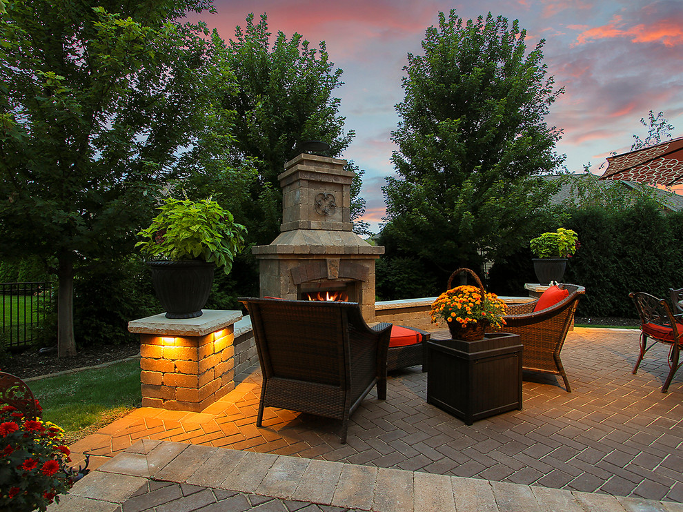 Small elegant backyard brick patio photo in Chicago with a fireplace and a roof extension