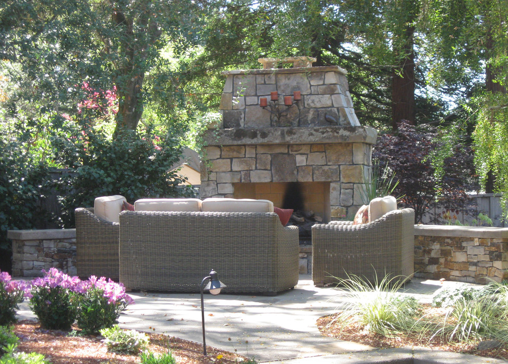 Immagine di un grande patio o portico chic dietro casa con un focolare, pavimentazioni in pietra naturale e nessuna copertura