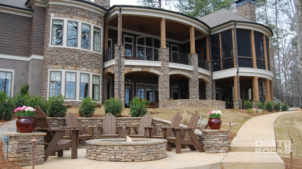 Inspiration pour une grande terrasse arrière traditionnelle avec un foyer extérieur, des pavés en pierre naturelle et aucune couverture.