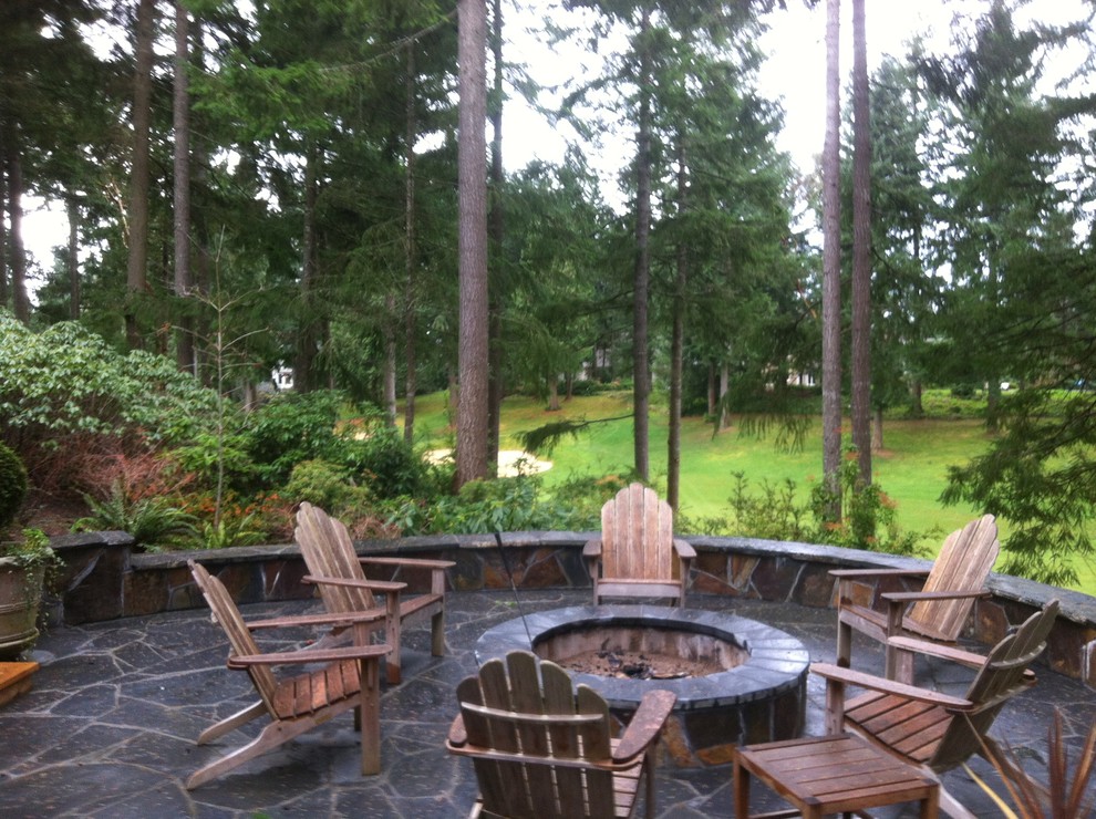 Foto de patio de estilo americano de tamaño medio sin cubierta en patio trasero con brasero y adoquines de piedra natural