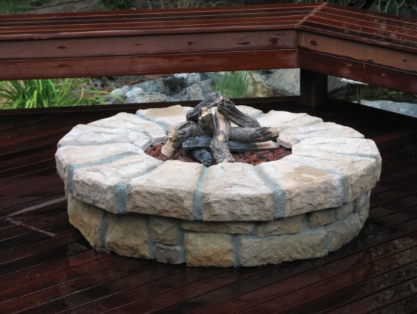 Imagen de patio de estilo americano de tamaño medio sin cubierta en patio trasero con brasero y adoquines de piedra natural