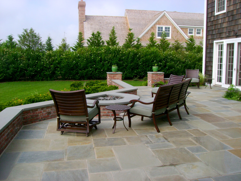 Foto di un patio o portico design di medie dimensioni e dietro casa con un focolare, piastrelle e nessuna copertura