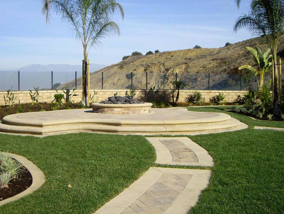 Inspiration for a large mediterranean back patio in Orange County with a fire feature, concrete paving and no cover.