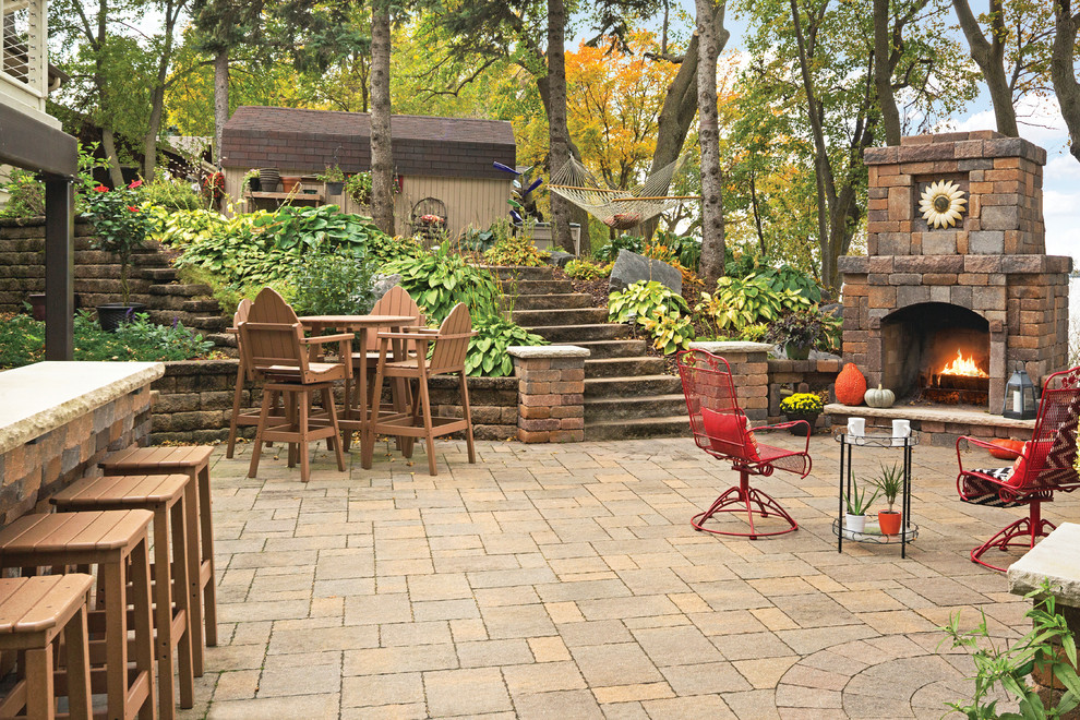 Inspiration for a rustic backyard concrete paver patio remodel in Other with a fire pit and no cover