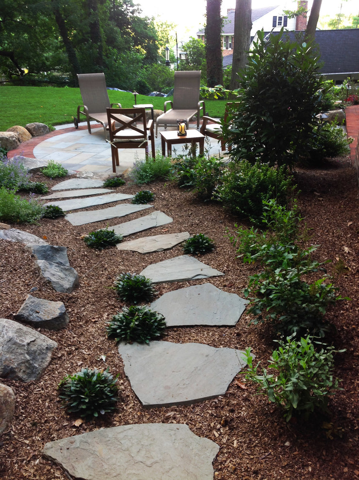 Example of a mid-sized classic backyard stone patio design in Philadelphia with a fire pit
