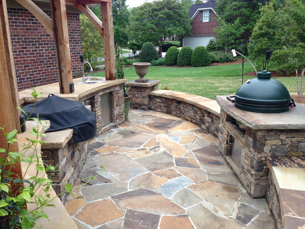 Foto di un grande patio o portico chic dietro casa con pavimentazioni in pietra naturale e una pergola