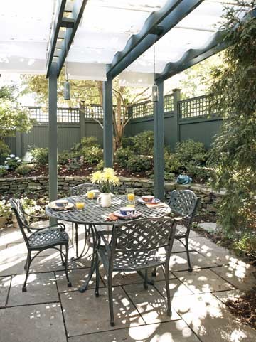 Imagen de patio clásico pequeño en patio trasero con adoquines de hormigón y toldo