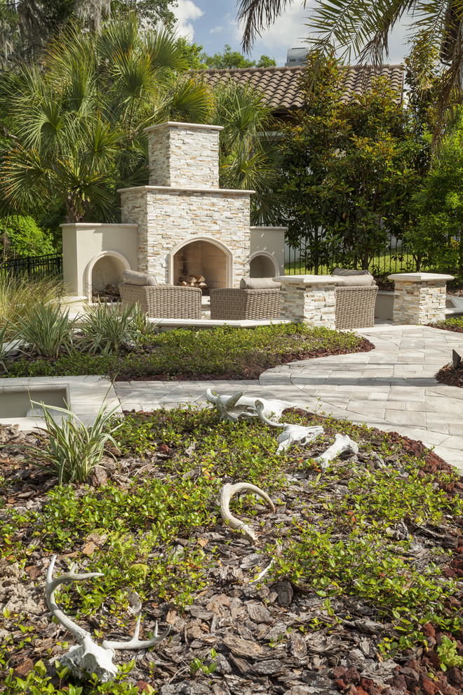 Inspiration for a large mediterranean backyard concrete paver patio remodel in Tampa with a fire pit and no cover