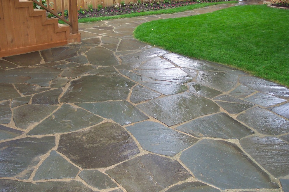 Ejemplo de patio tradicional renovado de tamaño medio sin cubierta en patio trasero con adoquines de piedra natural