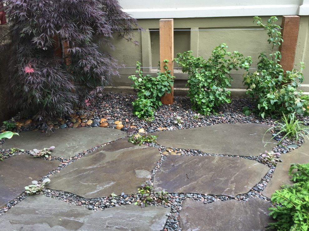 На фото: двор среднего размера на боковом дворе в стиле неоклассика (современная классика) с покрытием из каменной брусчатки без защиты от солнца