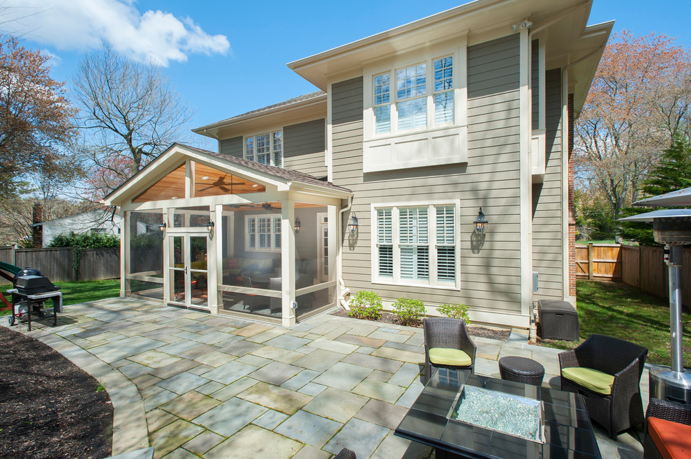 Exemple d'une terrasse arrière chic de taille moyenne avec une extension de toiture, un foyer extérieur et des pavés en béton.