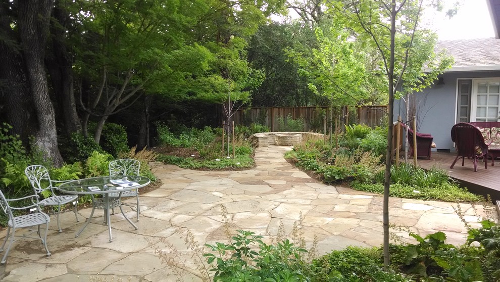 This is an example of a medium sized contemporary back patio in San Francisco with natural stone paving, a fire feature and no cover.