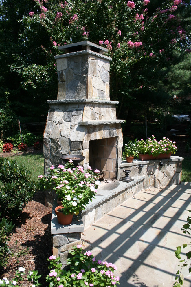 Inspiration for a mid-sized timeless backyard stone patio remodel in DC Metro with a fire pit and a pergola