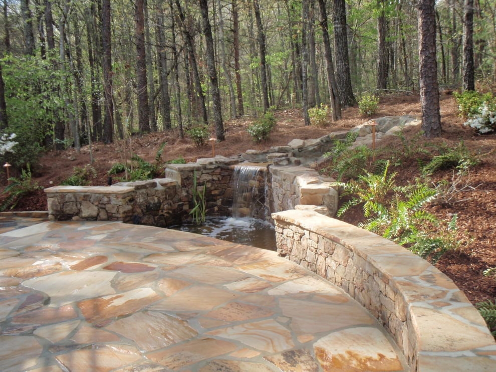 Photo of a medium sized rustic back patio in Birmingham with a water feature and natural stone paving.