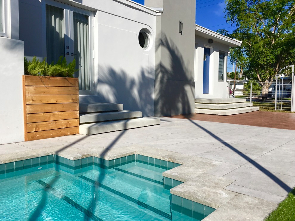 Esempio di un grande patio o portico minimalista dietro casa con piastrelle