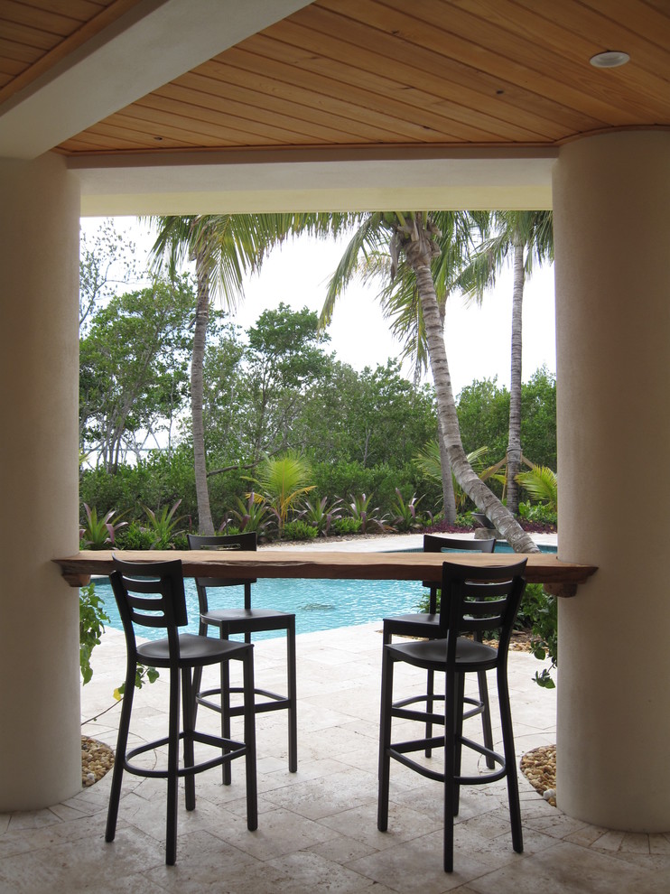Esempio di un patio o portico tropicale con un tetto a sbalzo