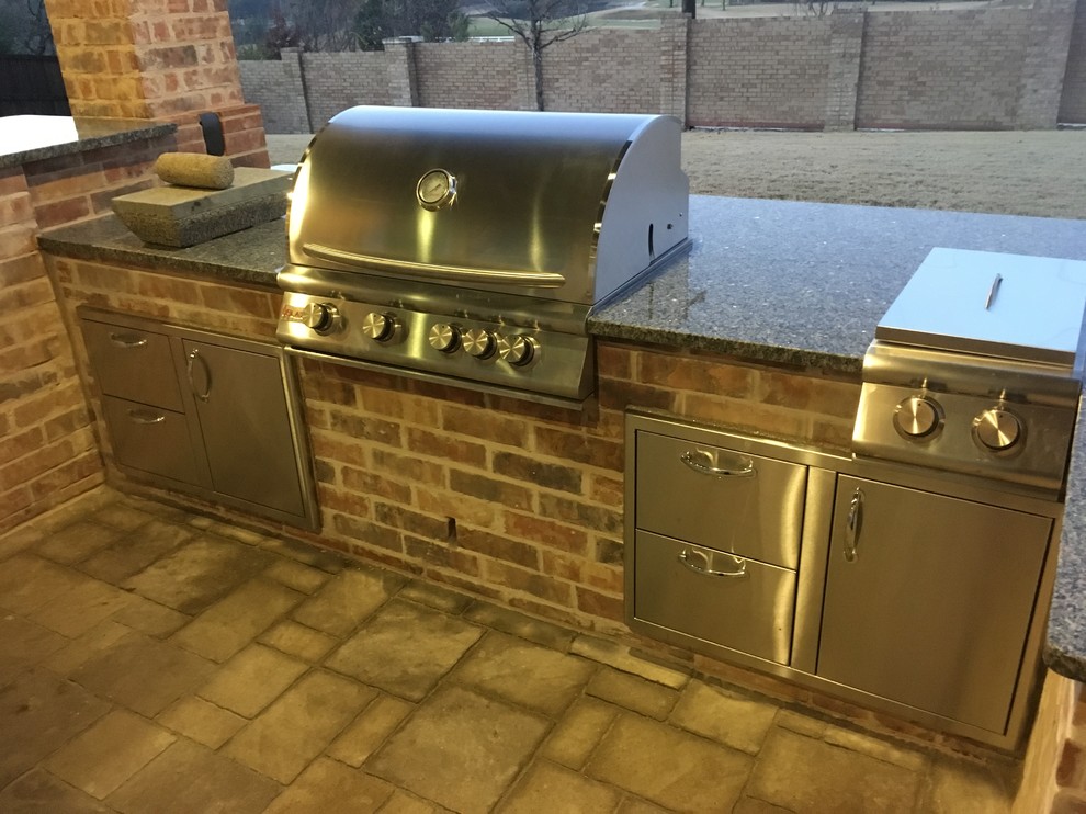 Inspiration for a medium sized traditional back patio in Dallas with an outdoor kitchen, brick paving and a roof extension.
