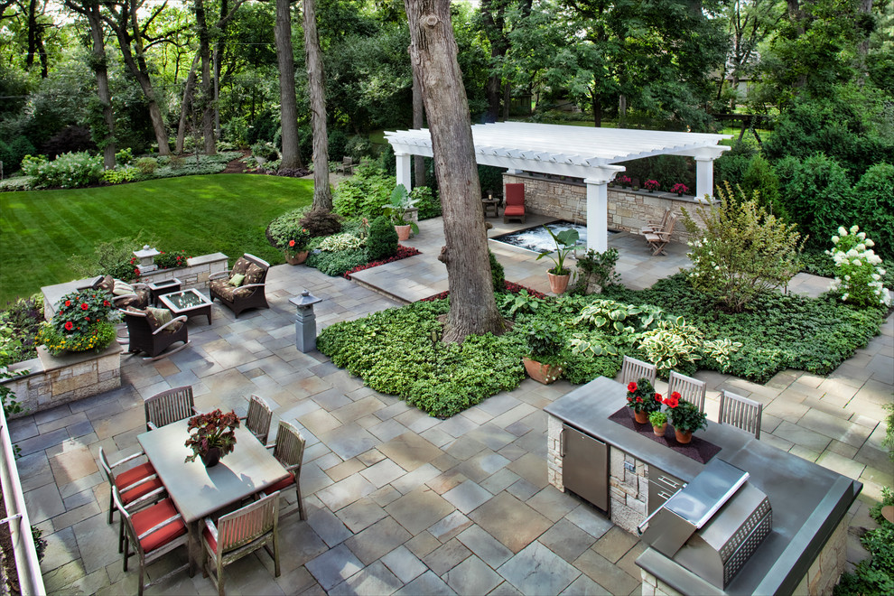 Inspiration for a large transitional shade backyard stone and wood fence landscaping in Chicago with a pergola for summer.