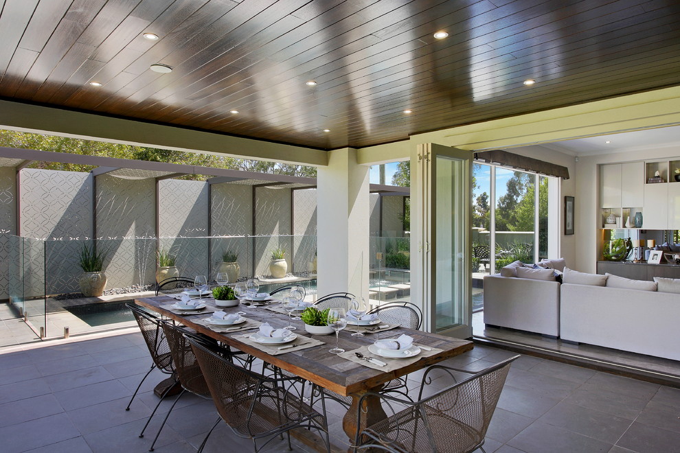 Идея дизайна: двор среднего размера на заднем дворе в современном стиле с покрытием из каменной брусчатки и навесом