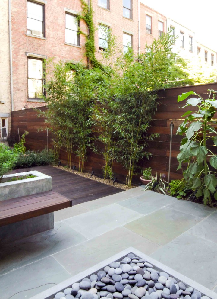 Modelo de patio moderno de tamaño medio sin cubierta en patio trasero con jardín de macetas y adoquines de piedra natural