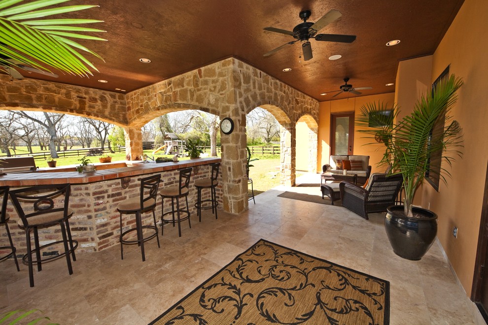 Patio kitchen - mid-sized mediterranean backyard patio kitchen idea in Houston with a roof extension