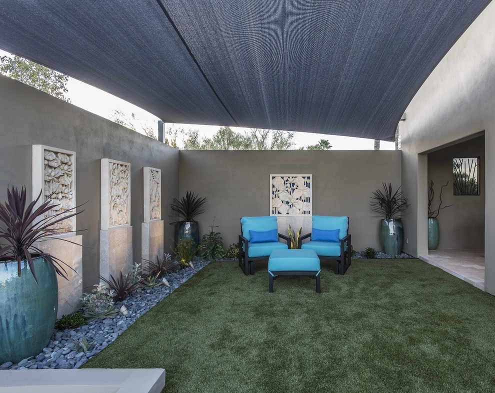 Design ideas for a large contemporary back patio in Phoenix with natural stone paving.