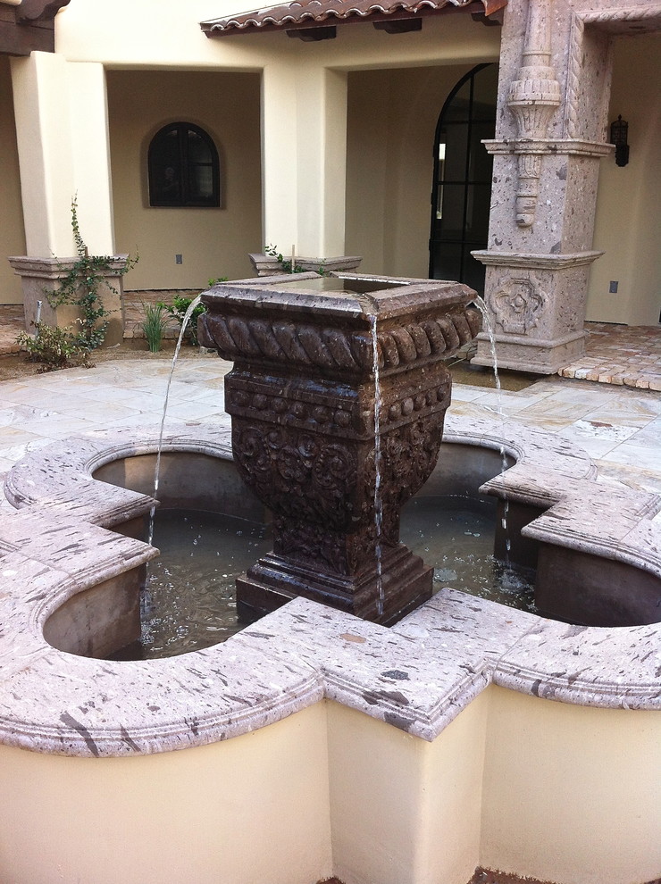 Imagen de patio mediterráneo de tamaño medio sin cubierta en patio con fuente y adoquines de hormigón