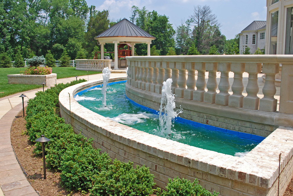 Foto di un grande patio o portico mediterraneo dietro casa con fontane, pavimentazioni in pietra naturale e un gazebo o capanno