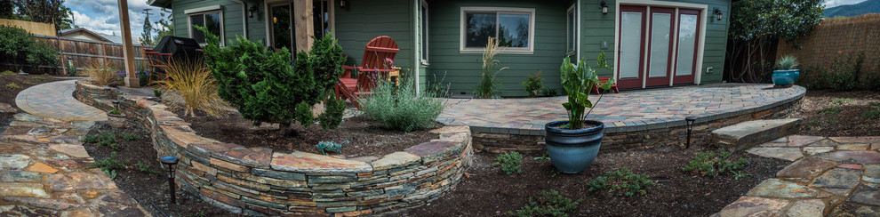 Immagine di un patio o portico stile americano di medie dimensioni e dietro casa con pavimentazioni in pietra naturale e una pergola