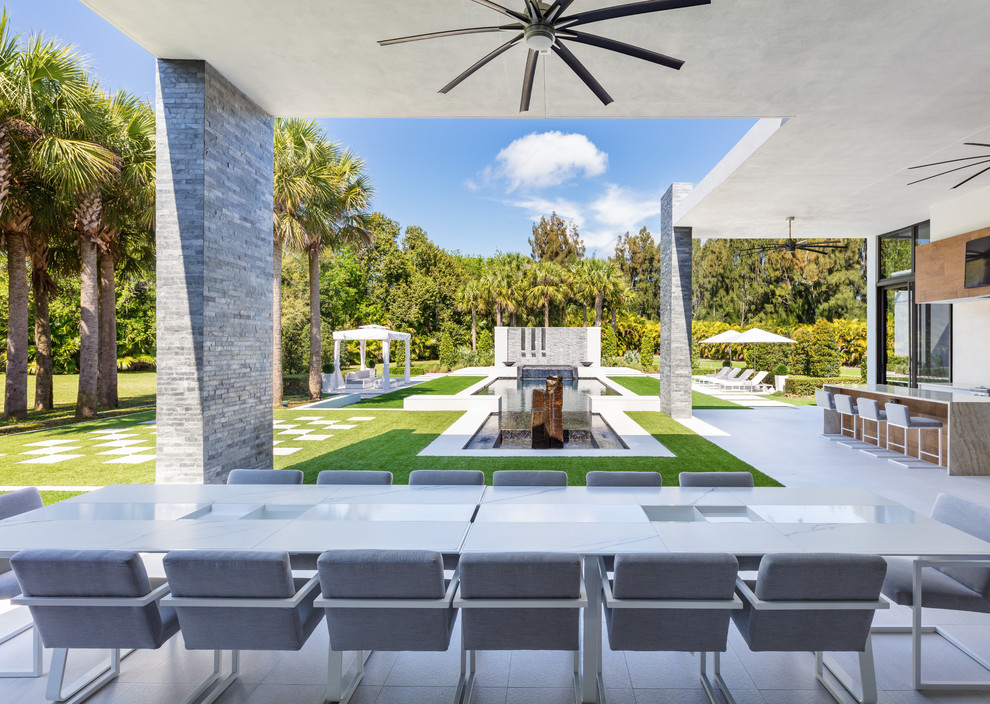 Inspiration for a contemporary back patio in Miami with a roof extension and a bar area.