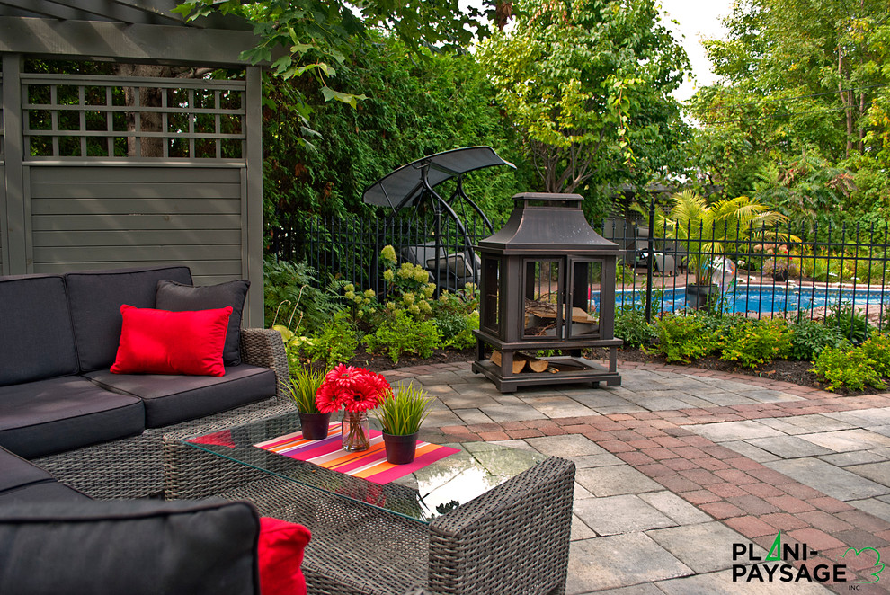 Inspiration for a medium sized contemporary back patio in Montreal with a fire feature, concrete paving and no cover.