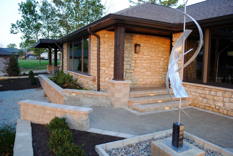 This is an example of a large contemporary front patio in Indianapolis with concrete paving and a pergola.