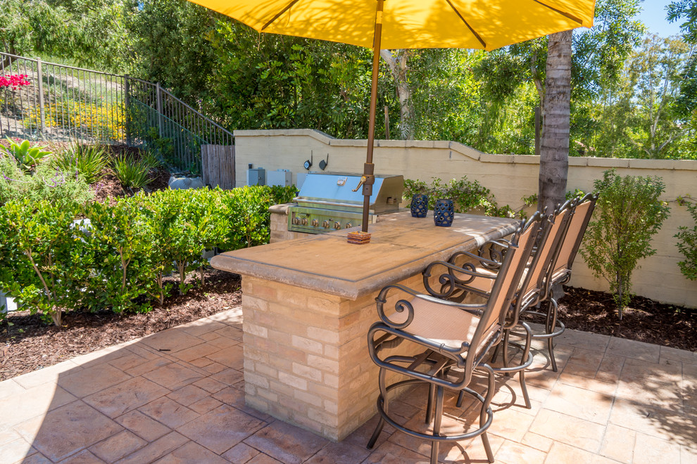 Inspiration for a medium sized mediterranean back patio in Orange County with an outdoor kitchen, tiled flooring and no cover.