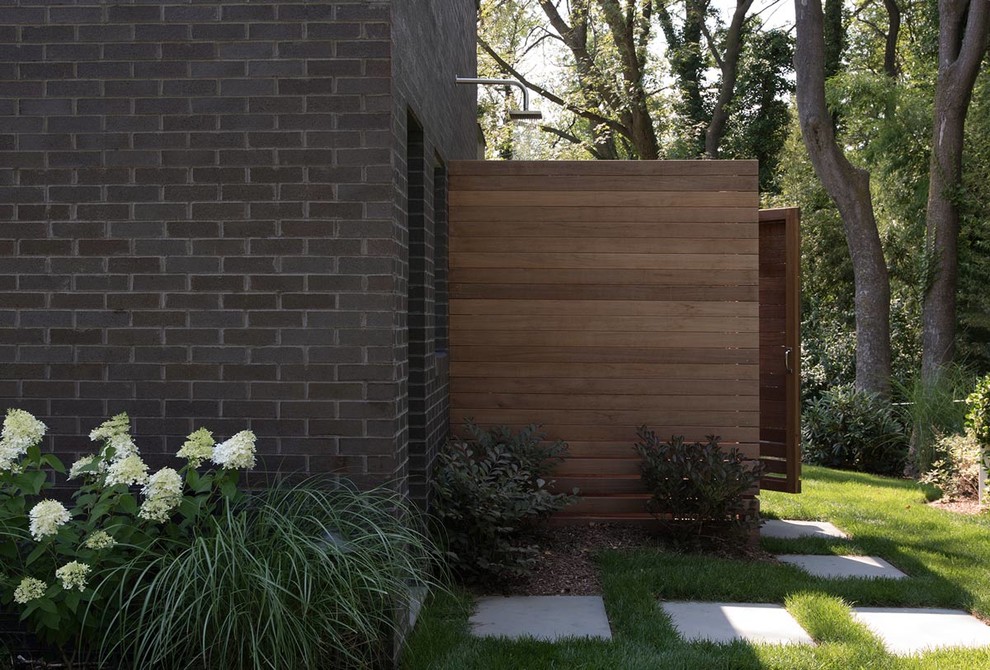 Überdachter Moderner Patio hinter dem Haus mit Gartendusche und Natursteinplatten in New York